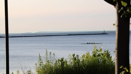 Tracking shot of row crew team at sunrise on a lake - Powered by Adobe