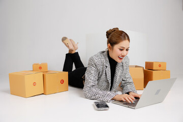 Portrait Asian smart entrepreneur business woman in casual suit surround by parcel boxes service...