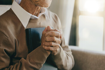 Old man Pray for god blessing to wishing to have a better life. hands praying to god with the bible...