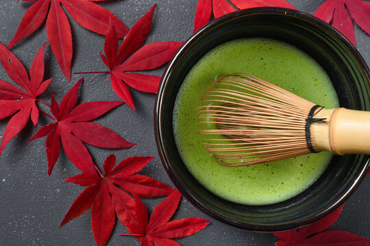 日本の茶道　茶碗と茶筅と抹茶と赤いもみじ 黒背景
Japanese Tea ceremony: Tea bowl, tea whisk, matcha and red maple leaves on black background	