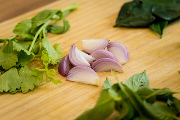 Cutting board with ingredients for preparing green curry with herbs and rice