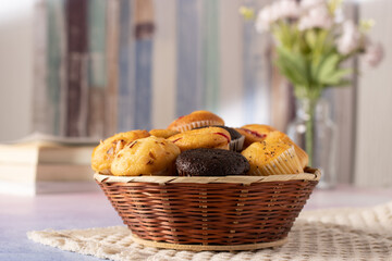 muffins on a table with books and flowers