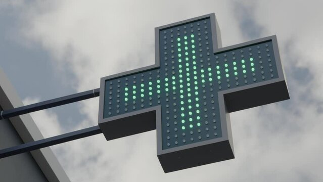 Pharmacy sign outside. Neon medical bright shining glowing green illuminated urban pharmacy drug store. Green cross indicating the location of a pharmacy. LED Pharmacy Cross Sign Animated Advertising.