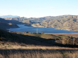 Obraz premium ELECTRICAL POLES RUN AMONG THE MOUNTAINS NEXT TO THE LAKE | CALIFORNIA USA