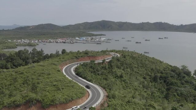 Establish aerial view of the combination of natural hills with the beauty of a small island in the middle of the sea at Puncak Mandeh, South Coast Regency, West Sumatra. d-log raw stock video