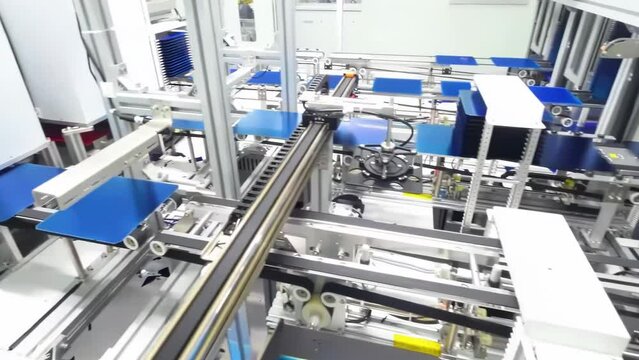 Photovoltaics production process solar panel assembly line operated by high tech robot arms in modern sustainable factory.