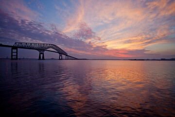 Sunrise over the Francis Scott Key Bridge spanning the Baltimore Inner Harbor of the Chesapeake Bay.