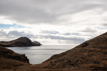 the ocean and hills are surrounded by clouds in a remote location