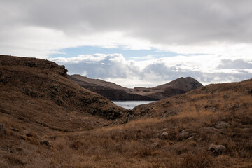 the ground beneath the hill is brown with grass and rocks