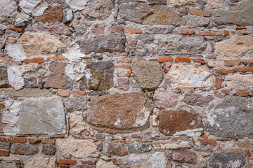 Historic stone wall. rough, old and worn ancient surface. big rock pieces.
