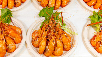 Red boiled crayfish in white plates as a background