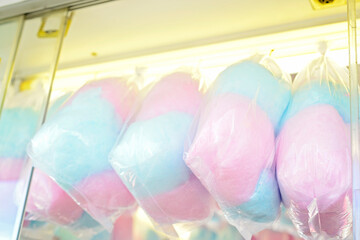 Colorful bags of cotton candy on display at a carnival, pink and