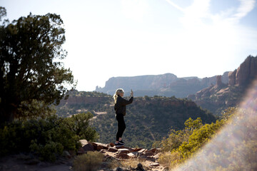 Woman capturing Sedona's vistas with a cell phone.