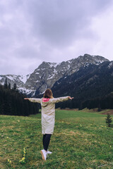 Active woman enjoys the beautiful scenery of the majestic mountains.