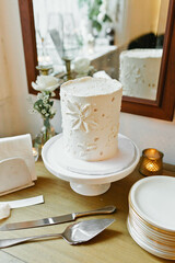 Elegant white floral wedding cake on vintage display
