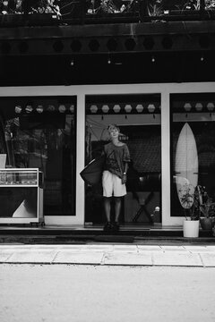 Portrait of young happy stylish woman with surfboard.