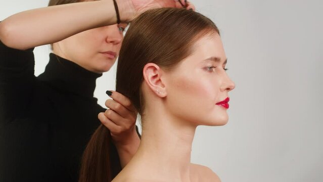 Beauty shot of woman makeup and hair artist doing hairstyle. Using hairspray for hair close-up.Concept of skincare, cosmetics, make up, beauty. Make-up and hair style tutorial 