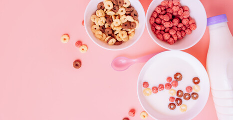 Corn rings without milk and with milk in white plates on a pink background.