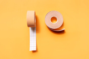 Adhesive tapes for the face in rolls on a yellow background.