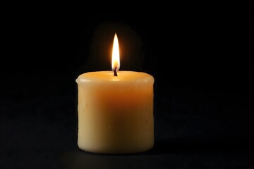 Glowing candle in the dark. Romantic candlelight creating a warm atmosphere in the black night.