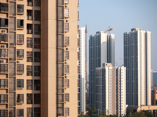 Established high-rise residential apartment buildings with the construction site of even taller, modern residences in the distance. City of Liuzhou, Guangxi, China. Concept of  Real estate development
