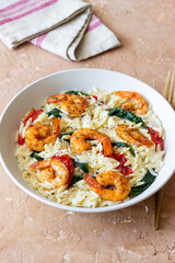 Orzo pasta with shrimp, spinach and tomatoes. Italian Cuisine. Seafood.