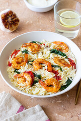 Orzo pasta with shrimp, spinach and tomatoes. Italian Cuisine. Seafood.