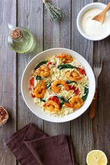 Orzo pasta with shrimp, spinach and tomatoes. Italian Cuisine. Seafood.