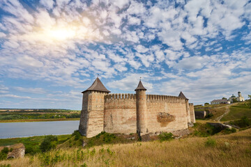 Khotyn fortress built in the 14th century. View of top of the fortress wall and towers among the hills closeup on background of Dniester river and its left bank at early springtime
