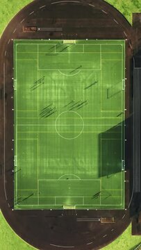 Vertical Screen: Captured from above, a dynamic aerial view showcases players on a sports field with vivid line markings, providing a vibrant backdrop for sports and competitive activities