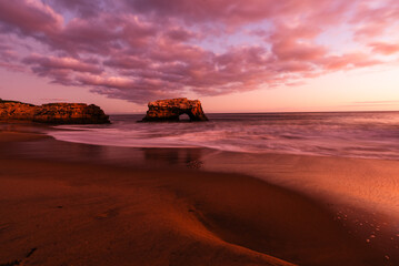 Natural Bridges in Santa Cruz at sunset with dramatic clouds.