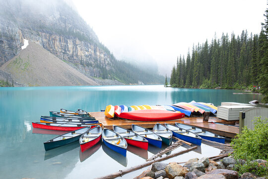 Colorful canoes surround a dock at Moraine Lake in Canada.