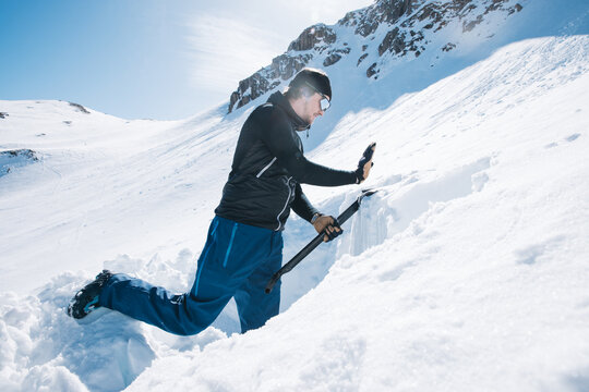 Man creating snow profile for avalanche control on snowy mountain