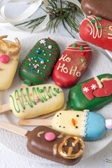 Christmas dessert. Sweet food. Cheesecake on a stick in the shape of ice cream. Children's treat in winter. Candy Christmas tree, snowman, deer and Santa Claus. Gingerbread cookies.