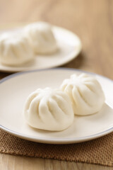 Steamed bun stuffed with barbecued pork, Asian cultural food on brown table background