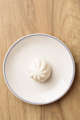 Steamed bun stuffed with barbecued pork, Asian cultural food on brown table background
