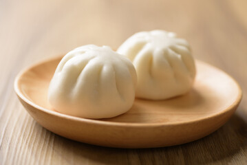 Steamed bun stuffed with barbecued pork, Asian cultural food on brown table background