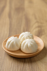 Steamed bun stuffed with barbecued pork, Asian cultural food on brown table background