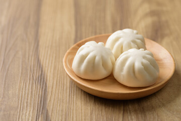 Steamed bun stuffed with barbecued pork, Asian cultural food on brown table background