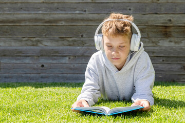 A boy relaxing on grass, listening to music