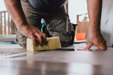 Fliesenlger arbeitet auf Terrasse