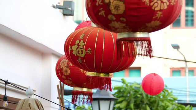 Slowmotion shot of colorful red and golden Chinese lanterns sold on an Asian street market prior to the Tet holiday or Lunar new year in Asia. TET concept. Travel to Asia. Letterings on lanterns and