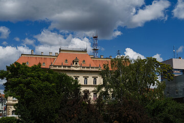 Obraz premium Architecture of the small town Zrenjanin in Serbia, Vojvodina district. The old yellow government building with carved patterns and a red tiled roof.