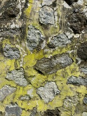 Obraz premium A stone wall attached by cement, covered by moss