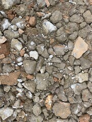 A pile of rocks and rubble with a few small stones scattered around. The image has a rough and rugged appearance, with a sense of decay and abandonment