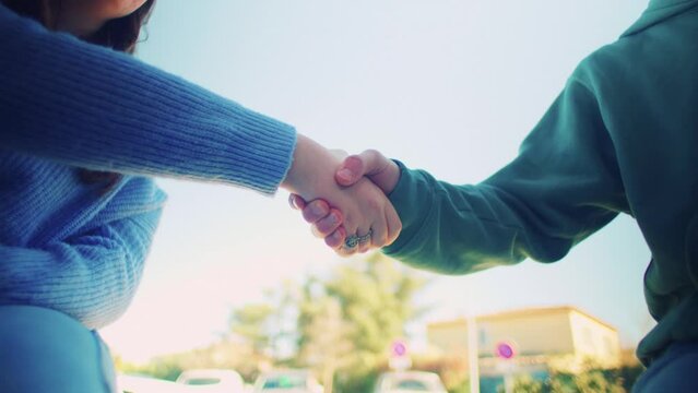 Students Shaking Hands Outside at the Sun