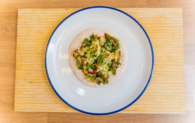 Tasty bean porridge with cauliflower and vegetables on white plate