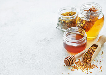 Raw organic bee pollen and honey in jars.