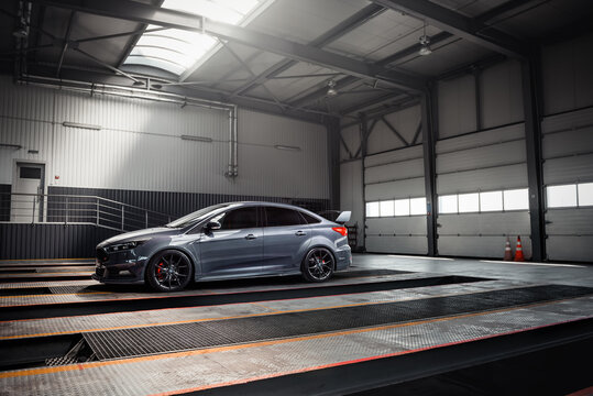 grey Ford Focus ST in big airy garage. Side view of sedan parked in empty warehouse. Lviv, Ukraine - April 17 2016.