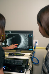 in an ophthalmology clinic young doctor after an eye ultrasound shows the results to a girl